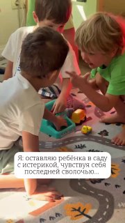 Три ребёнка играют с игрушками на ковре в группе детского сада; сцена показывает взаимодействие, эмоции и момент адаптации в коллективе.