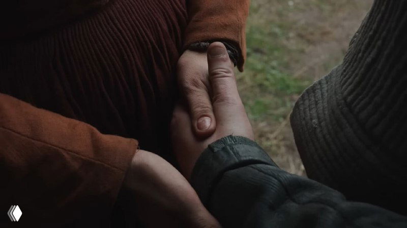 Крупный план сцены рук, сцеплённых в жесте поддержки: символ бытовой близости, утраты и тех тихих связей, которые держат семью вместе.