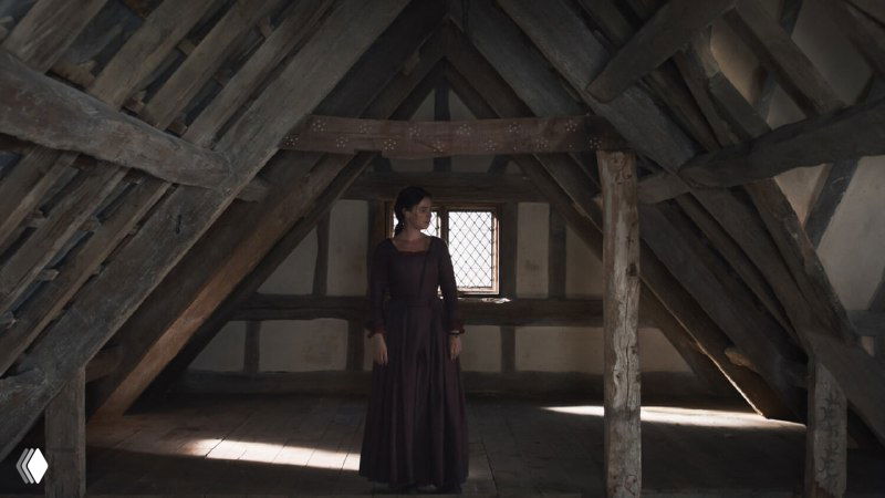 Героиня на чердаке у одинокого окна: пространство и свет подчёркивают её внутреннюю изоляцию, созерцание и размышления после утраты.