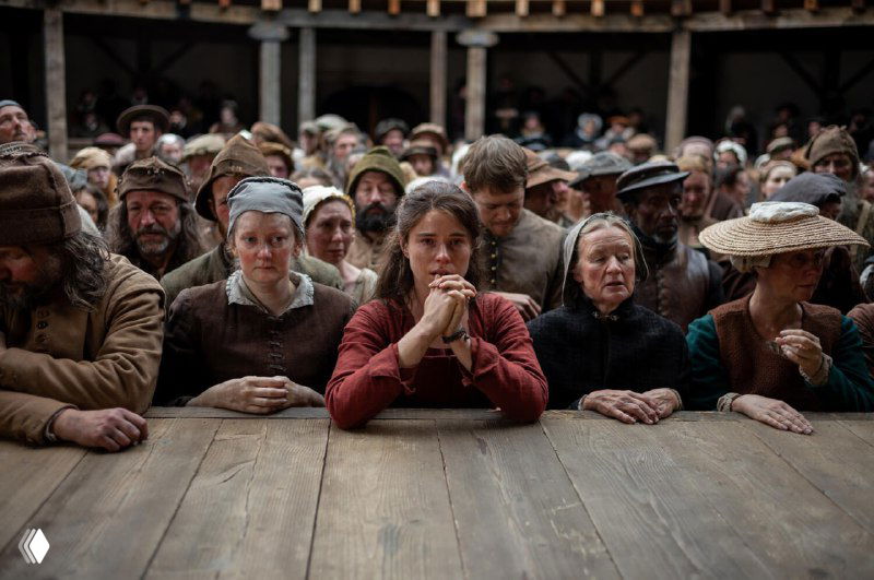 Зрительный зал в исторических костюмах: в центре кадра фигура в красном, внимание публики и ощущение общественной сцены как контраста к личной трагедии.