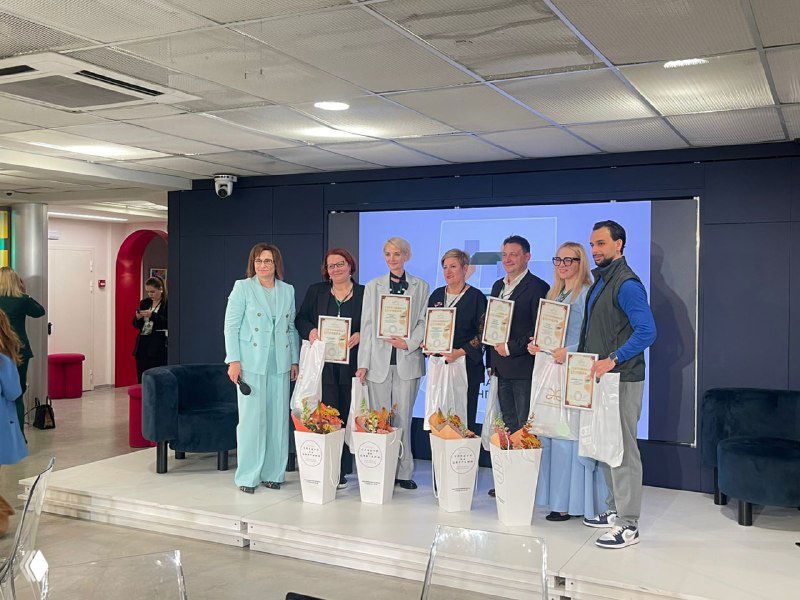 Награждение участников на сцене: люди с сертификатами и подарками после завершения обучающей программы или практикума.