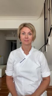 Юлия Краева в белой медицинской форме, смотрит в камеру в интерьере; фото для анонса видео о технике для век.