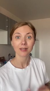 Видеокадр: Юлия Краева, косметолог и тренер по фейспластике, крупный план лица в квартире перед демонстрацией техники массажа.