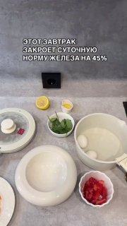 Фото ингредиентов для завтрака: зелёная гречка, помидоры, шпинат, яйца, авокадо, красная рыба, семена тыквы и дольки лимона на столе.