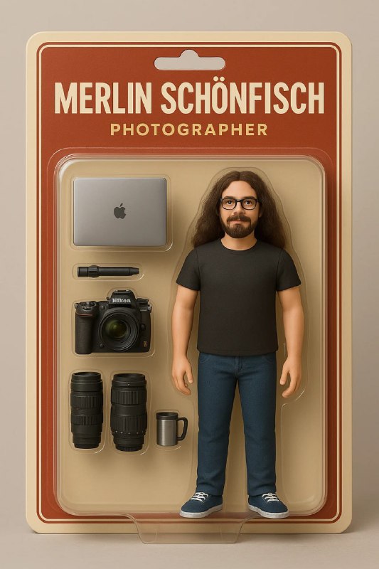 Блистеры с мини‑фигурками: персонаж в очках и аксессуары вроде ноутбука и камеры, упаковка в ретро‑стиле с именем автора.