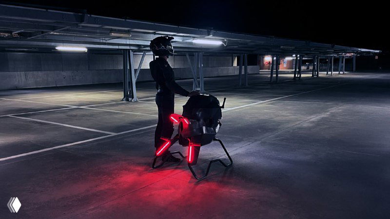 Ночное фото прототипа Volonaut Airbike на стоянке с включёнными красными габаритными огнями; подчёркнута конструкция опор и подсветки для безопасной посадки.