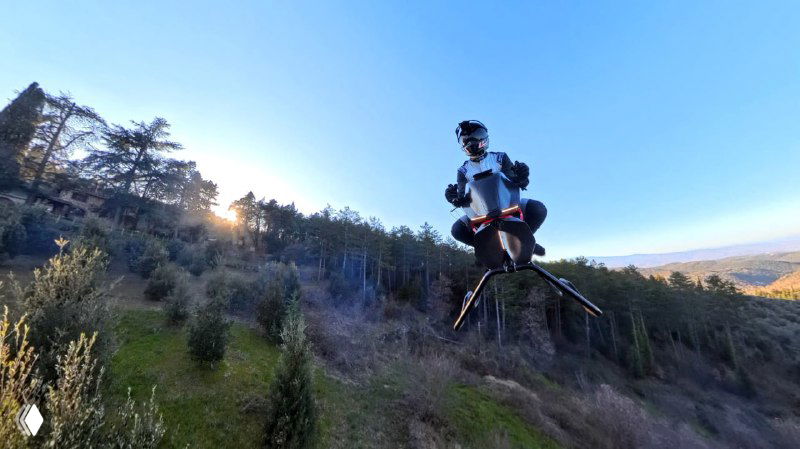 Польотный кадр: Volonaut Airbike с пилотом в шлеме поднимается над лесистым склоном на фоне заходящего солнца; видны посадочные ноги и корпус аппарата.