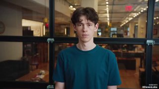 Кадр с видео: молодой мужчина на фоне офисного пространства — иллюстрация доклада или интервью в рамках конференции Google.