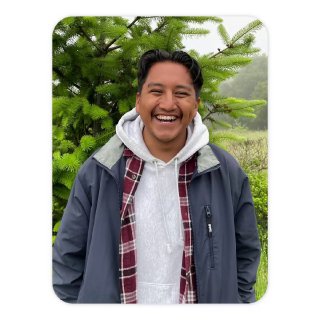 Фотопортрет улыбающегося человека на фоне зелёной листвы — пример кадра, доступного для редактирования с новыми ИИ‑инструментами Google Photos.