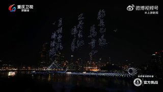 Дроны формируют световые иероглифы над рекой: видна стройная надпись из точек-светодиодов на ночном небе и городской силуэт.