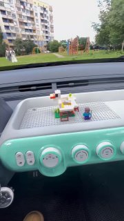 Интерьер Bestune Pony: мятная панель приборов с решёткой-подставкой для Lego, простой дизайн приборной панели и органы управления на видном плане.