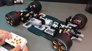 Шасси и механика Tongshengju на рабочей поверхности: передача, подвеска и радиоуправление в разборе, видна пультовая система.