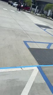 Фрагмент парковочной территории рядом с Tesla Diner: разметка пешеходных переходов и место для парковки автомобилей при дневном освещении.