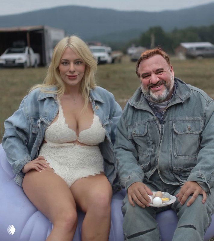 Женщина в белом кружевном наряде сидит рядом с мужчиной на фоне полевых палаток; изображение выглядит как обработанная или сгенерированная сцена свидания.