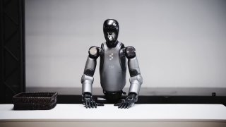 Гуманоидный робот Figure в лабораторной обстановке: демонстрационный кадр, где робот аккуратно и автономно складывает полотенца.