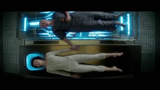 Кадр из сериала «Чужой: Земля»: персонаж в светлом костюме лежит в капсуле, рядом стоит другой человек — атмосферный научно‑фантастический кадр.