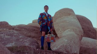 Человек в яркой одежде на фоне массивных камней; фото служит иллюстрацией к анонсу Google nano banana — ИИ‑фотошоп.