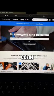 Скриншот главной страницы iFixit на экране ноутбука, виден заголовок «Исследуйте мир ремонта», превью инструкций и часть клавиатуры на фоне.