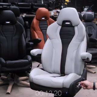 Ряд спортивных сидений в шоуруме, на переднем плане белое кресло в стиле BMW M5 с выраженными боковыми валиками и электроникой.