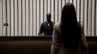 Робот Figure 03 в формальной обстановке напротив человека, акцент на гуманоидном облике и взаимодействии с людьми в ситуациях обслуживания или приёма.