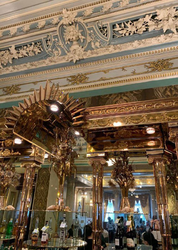 Декоративные элементы столовой: зеркала, позолоченные колонны и сложная лепнина, создающие ощущение дворцового зала для обедов