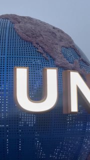 Крупный план букв на глобусе Universal в парке Пекин: синие панели, подсветка и фокус на надписи у входа в тематический парк.