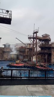 Сцена с пирсами и декорациями для шоу у воды: платформа, оборудование и элементы для постановочных трюков в парке развлечений.