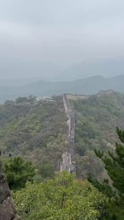 Вертикальный кадр с протяжённым участком Великой Китайской стены, уходящим в туманистую долину — глубокая перспектива и горный ландшафт.