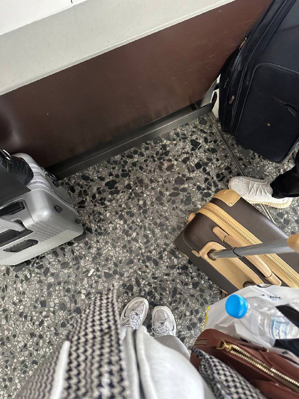 Фото багажа на платформе: чемоданы и сумки автора, вид снизу на обувь и дорожные принадлежности перед дальней дорогой после прогулки по стене.