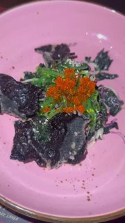 Авторский тёмный ресторанный блюдо на розовой тарелке: гастрономия острова, необычная подача и детали сервировки.