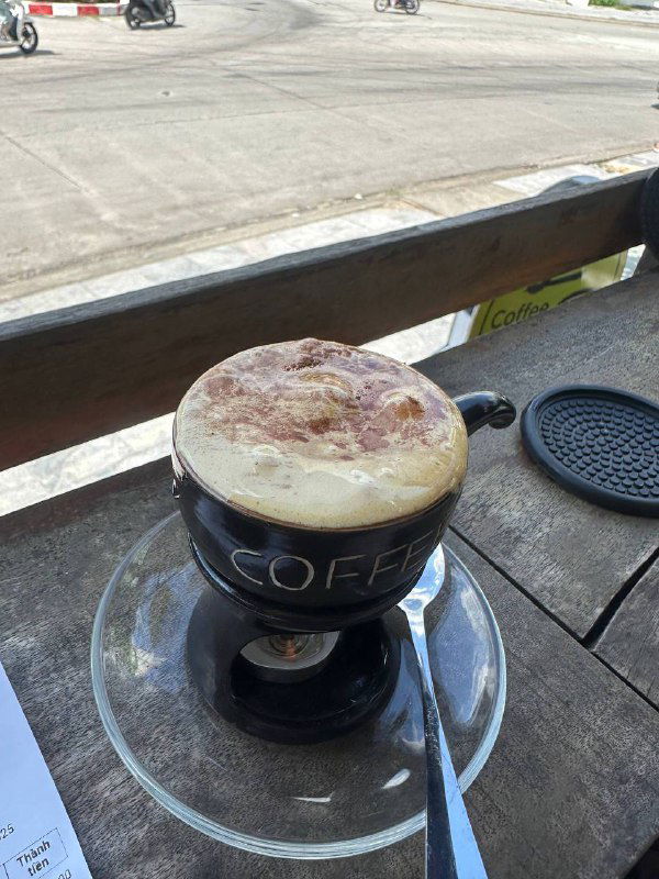 Чашка кофе на столе на открытой веранде у дороги — пауза и передышка после дороги на фоне уличного вида острова Боракай.