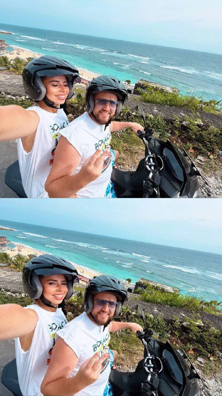 Селфи пары на скутере у моря — мастер и мужчина улыбаются в шлемах, кадр иллюстрирует тренировку на близком человеке.