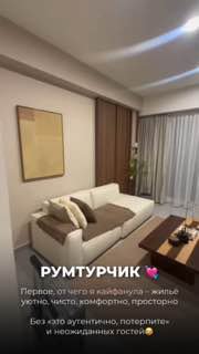 Интерьер современных апартаментов: светлая гостиная с диваном, столиком и шторами — уютное жильё для длительного проживания и работы.