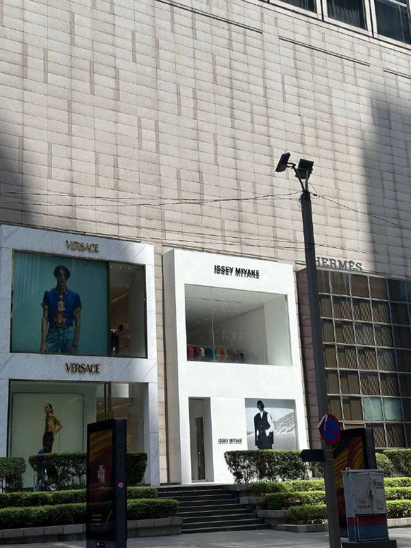 Фасады люксовых бутиков в торговом районе с витринами и брендовой атмосферой — городской ритм и шопинг в Азии.