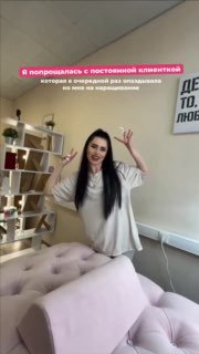 Анастасия Вугринчук в студии на фоне кушетки и полок с косметикой, улыбается и машет рукой — кадр из видео о конфликте с клиенткой.