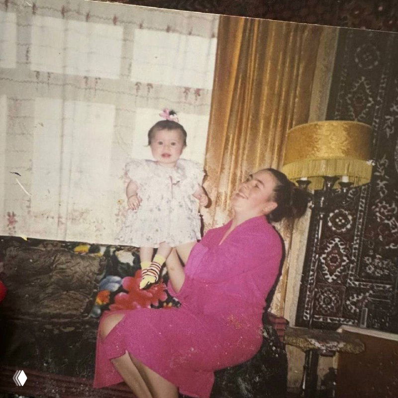 Старая фотография: мама держит младенца в платье в интерьере советской квартиры, отражая семейную историю и корни автора поста.