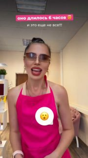 Мастер в защитной маске и очках в салоне держит инструменты для наращивания ресниц — кадр из рабочего процесса.