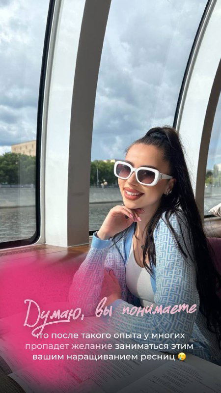 Улыбчивое фото на прогулке: автор в белых солнцезащитных очках на фоне панорамного окна, настроение после работы.