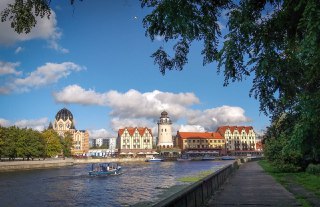 Набережная с лодками и исторической застройкой у воды — образ прогулок по центру Калининграда или уютных прибрежных районов для семейных поездок.