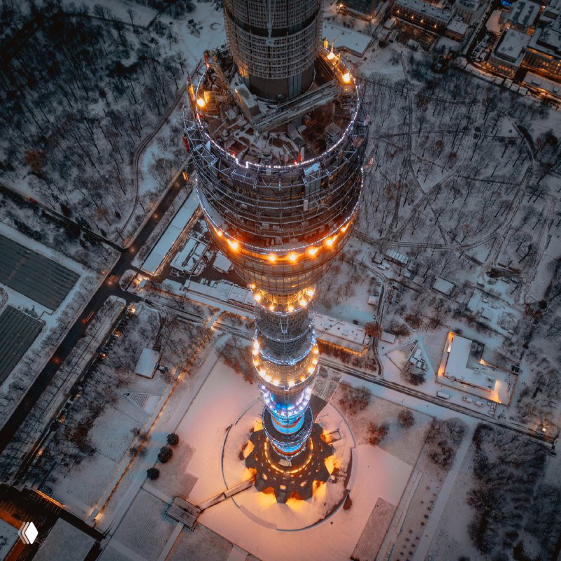 Аэрофотоснимок Останкинской телебашни со снежной окрестностью, демонстрирующий идею подняться на смотровую площадку и посмотреть город сверху.