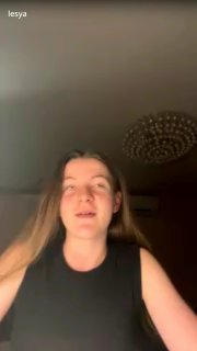 Вертикальный кадр: участница разговорного клуба Олеся говорит в комнате, видна люстра на потолке и тёплое освещение.