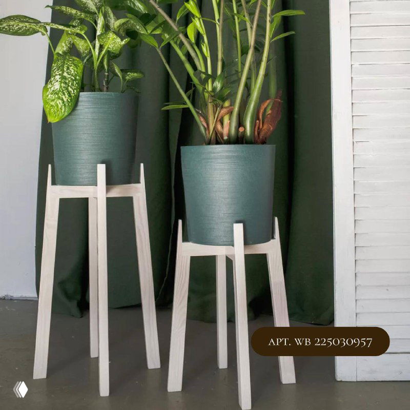 Пара светлых деревянных подставок в скандинавском стиле с зелёными растениями на них, фон — тёмная штора, контрастный интерьерный кадр