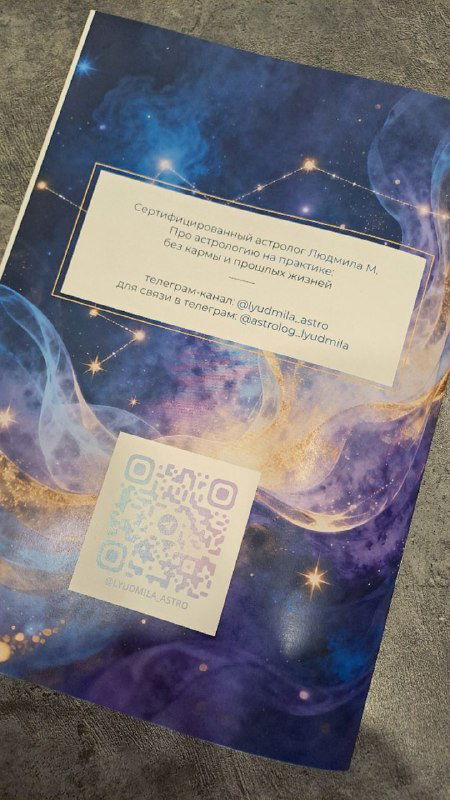Обложка астрологического каталога синего космического оформления с рамкой и QR-кодом в центре — видна ламинация и декоративные звезды на фоне.