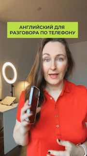 Мария Малышева держит мобильный телефон на фоне рабочего стола — превью к статье о фразах для телефонного разговора на английском