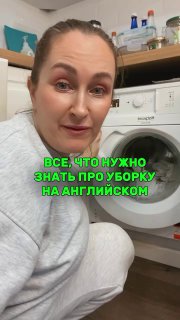 Женщина в домашней прачечной рядом со стиральной машиной; на полках видны средства для уборки и текст‑плашка про фразы для уборки.