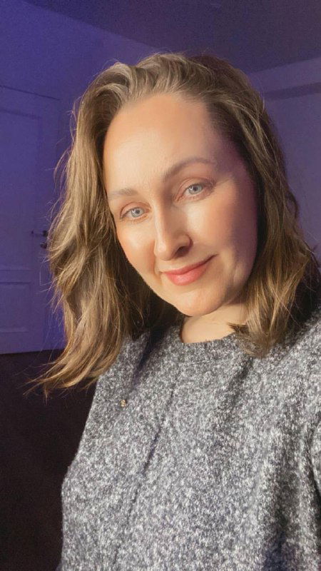 Крупный план женского портрета при мягком естественном свете в домашней обстановке, нейтральная мимика и естественные тона.