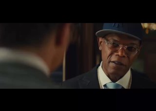 Кадр‑превью: крупный план мужчины в очках и шляпе в строгом костюме, разговорная сцена в тёплом интерьерном фоне — видеокадр анонса