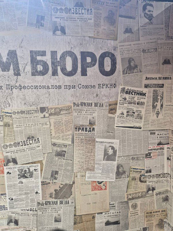 Коллаж из старых газет на стене выставочной зоны — декоративная стена с историческими газетными заголовками в стиле инсталляции.