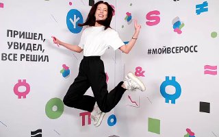 Гость прыгает в фотозоне Bullet Time на фоне яркого брендированного баннера с геометрическими элементами и хештегом, демонстрируя эффект движения.