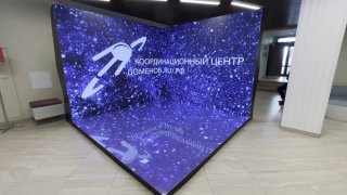 Угловая LED‑фотозона из светодиодных экранов с эффектом звёздного неба, установленная в холле как фон для фото и видео.